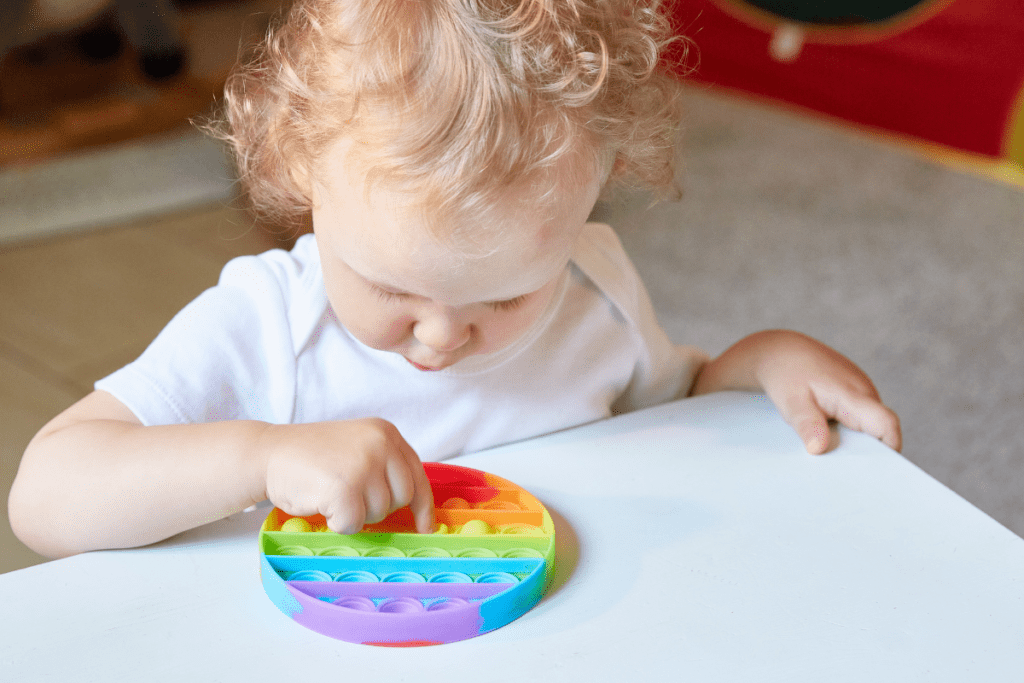 Les Mains Des Bébés Tiennent Le Jouet Anti-stress Popit. L'enfant